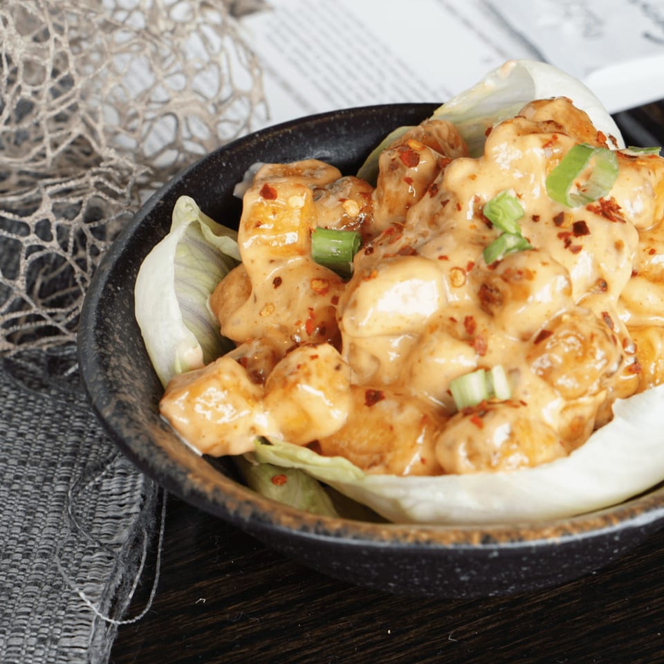 Inchin's Bamboo Garden's Asian-fusion shrimp dish, coated in creamy sauce, chili flakes, and green onions.