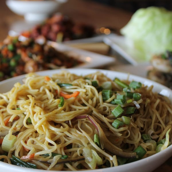 A close-up of Inchin's Bamboo Garden's Asian-fusion noodles with vegetables and scallions.