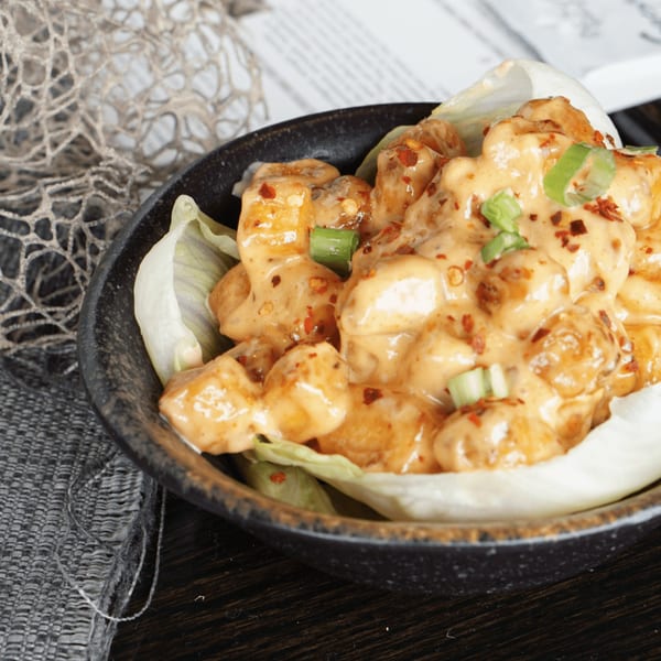 Inchin's Bamboo Garden's Asian-fusion shrimp dish, coated in creamy sauce, chili flakes, and green onions.