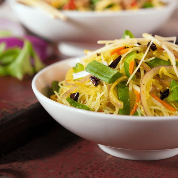 Close-up of Inchin's Bamboo Garden's Asian-fusion noodles with vegetables in a white bowl.
