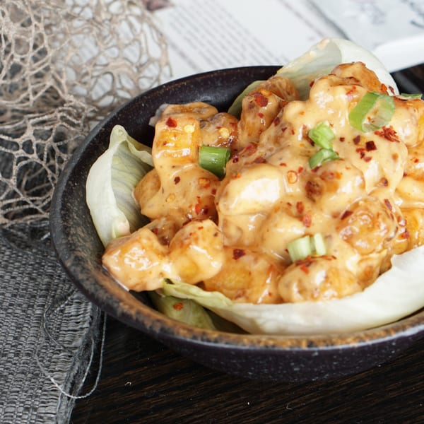 Inchin's Bamboo Garden's Asian-fusion shrimp, coated in a creamy sauce, garnished with chili flakes and scallions.