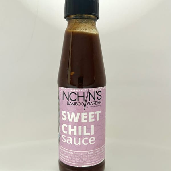 A bottle of Inchin's Bamboo Garden Sweet Chili Sauce with a pink label.