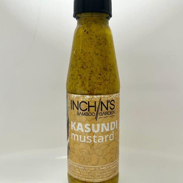Inchin's Bamboo Garden Kasundi mustard in a clear bottle with a black cap on a white background.