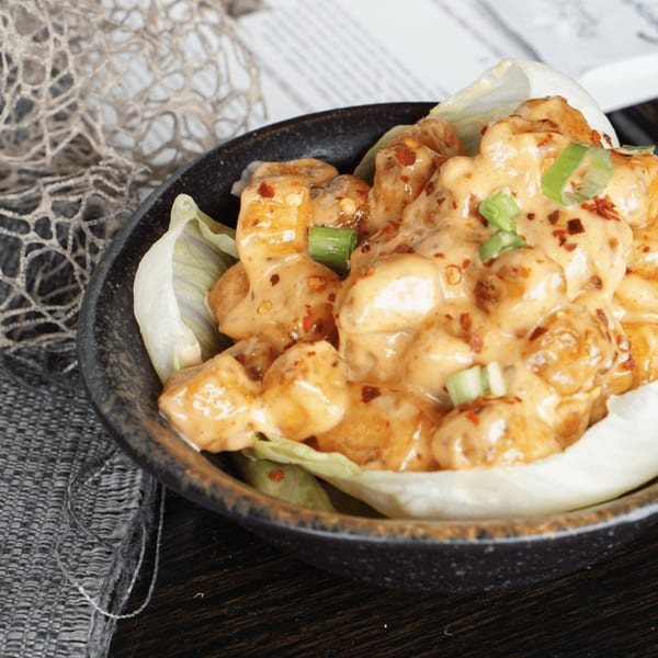 Inchin's Bamboo Garden's Asian-fusion shrimp dish, coated in creamy sauce, chili flakes, and green onions.
