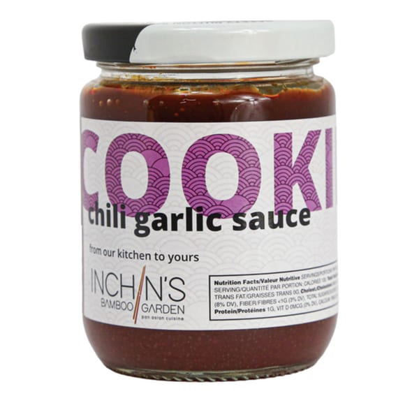 A jar of Inchin's Bamboo Garden chili garlic sauce with a white label and black lid.