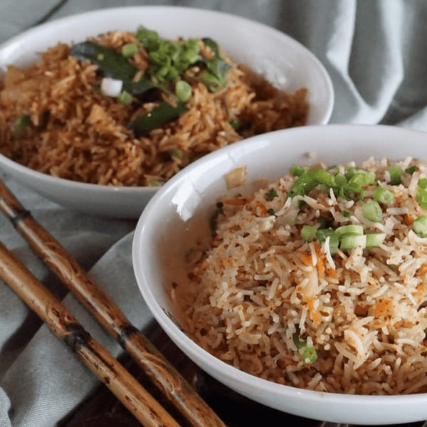 Two bowls of Inchin's Bamboo Garden fried rice, one light and one dark, with chopsticks.